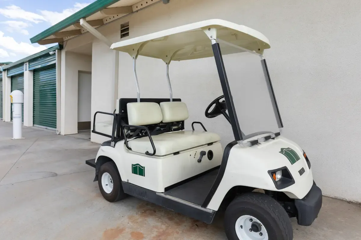 Golf cart parked in front of storage units.