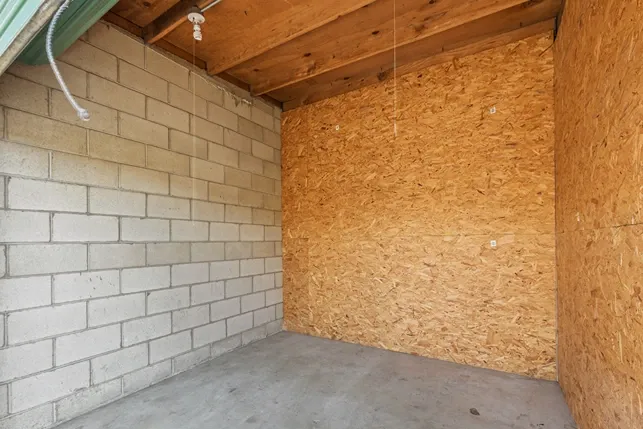 Interior of a wood and concrete walled storage unit.