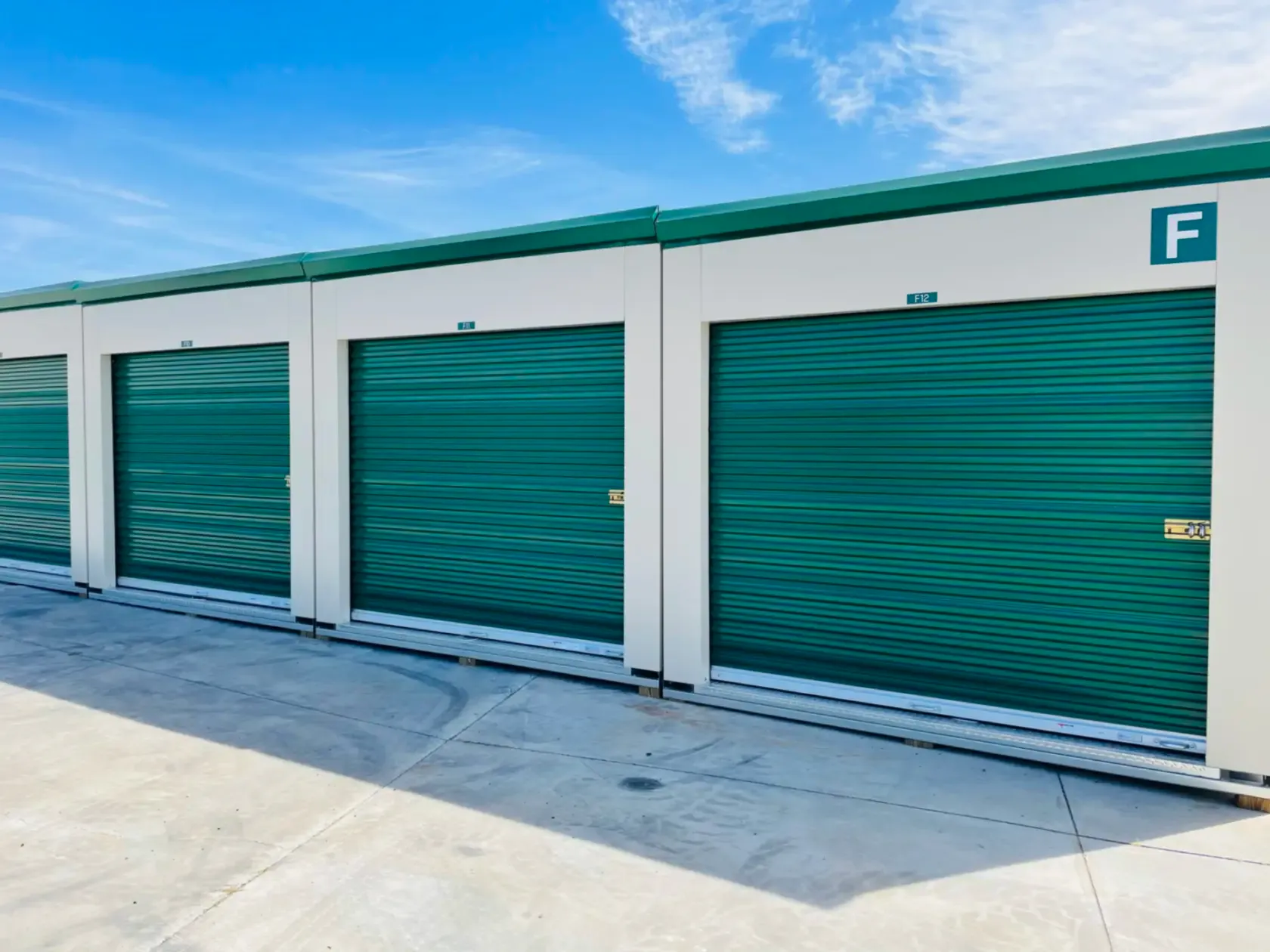 Large green outdoor storage units in a row.